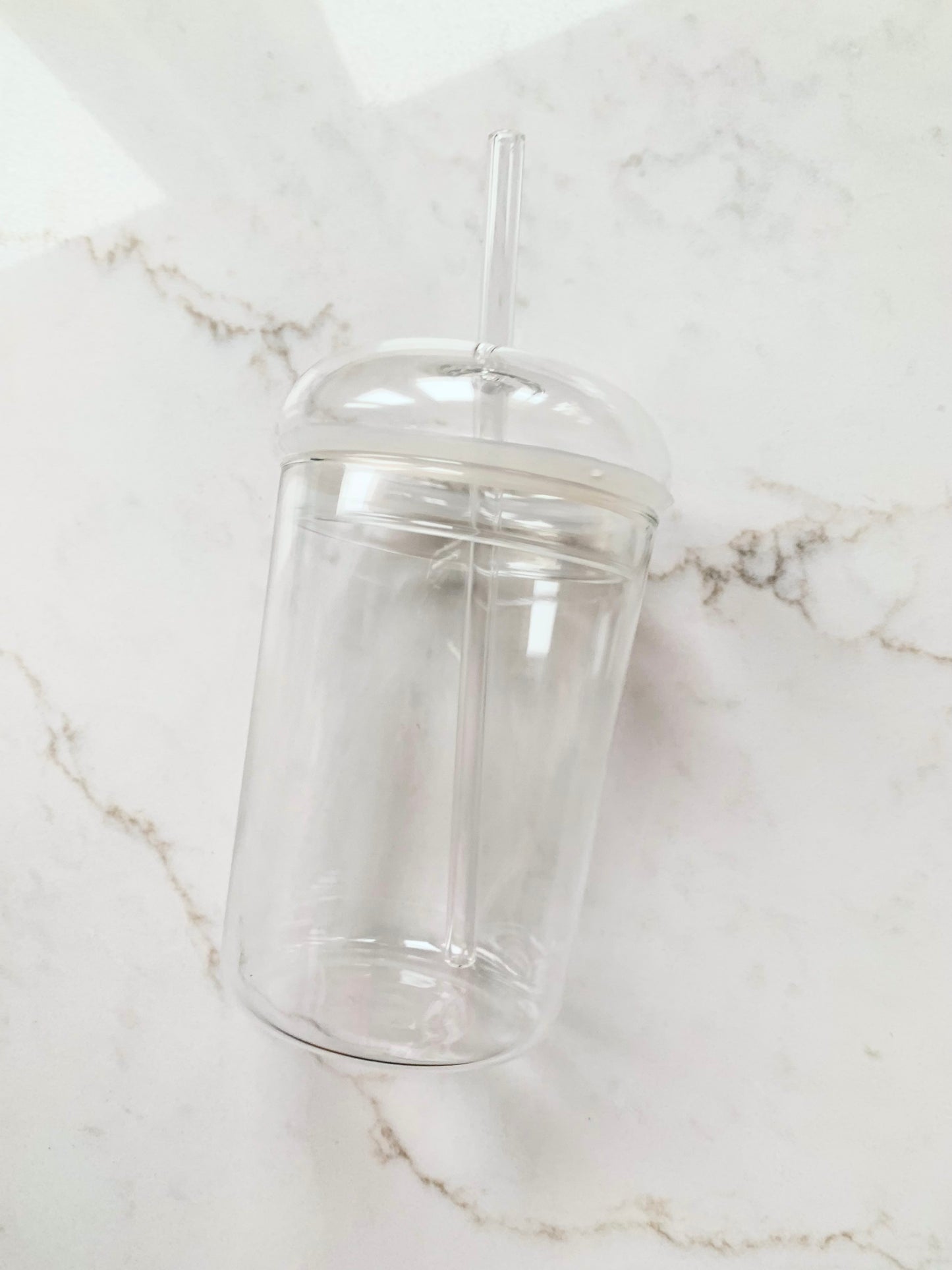 Vaso de vidrio transparente con pajita